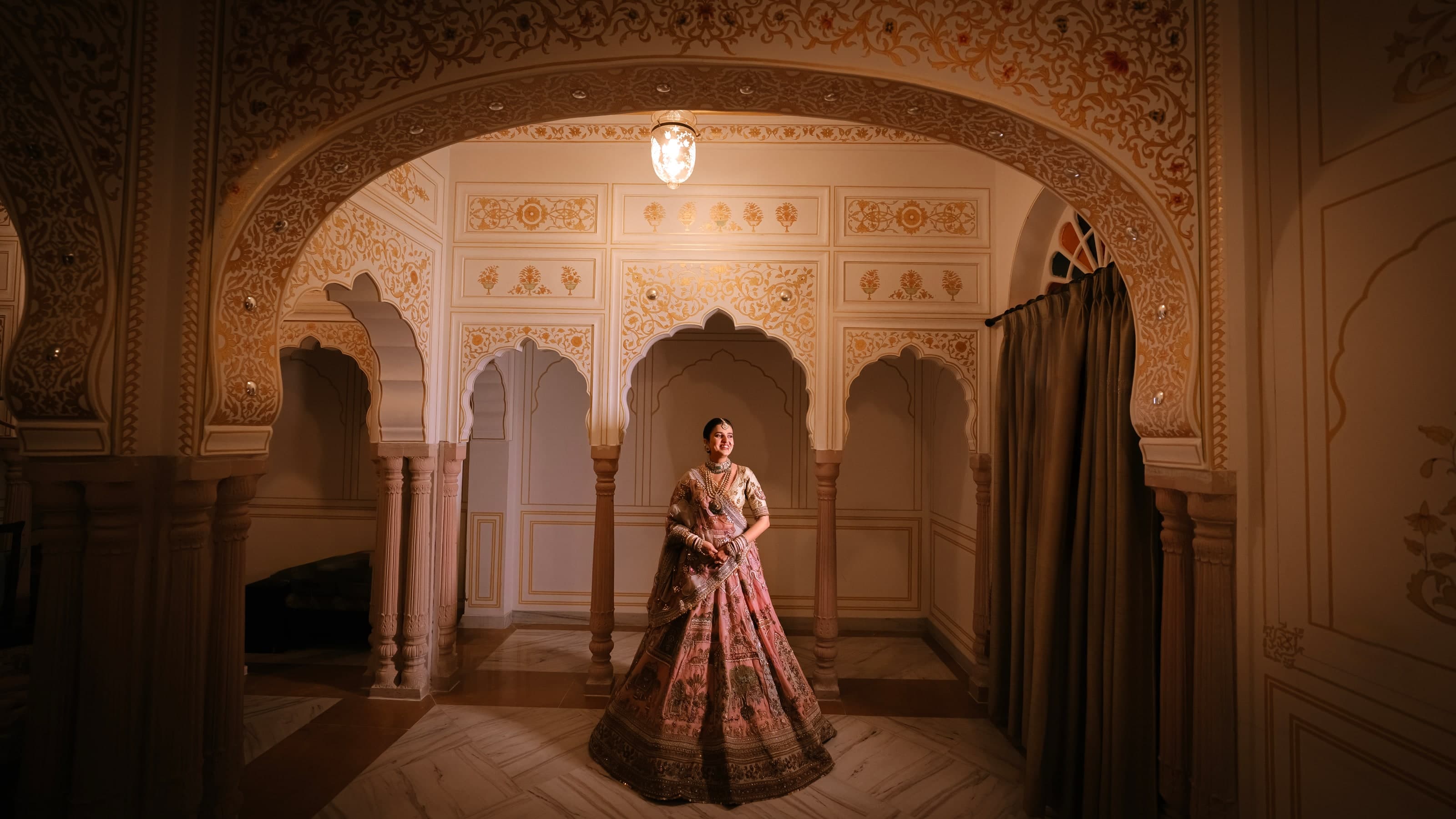 Bride standing beneath the ornate arches of a heritage palace